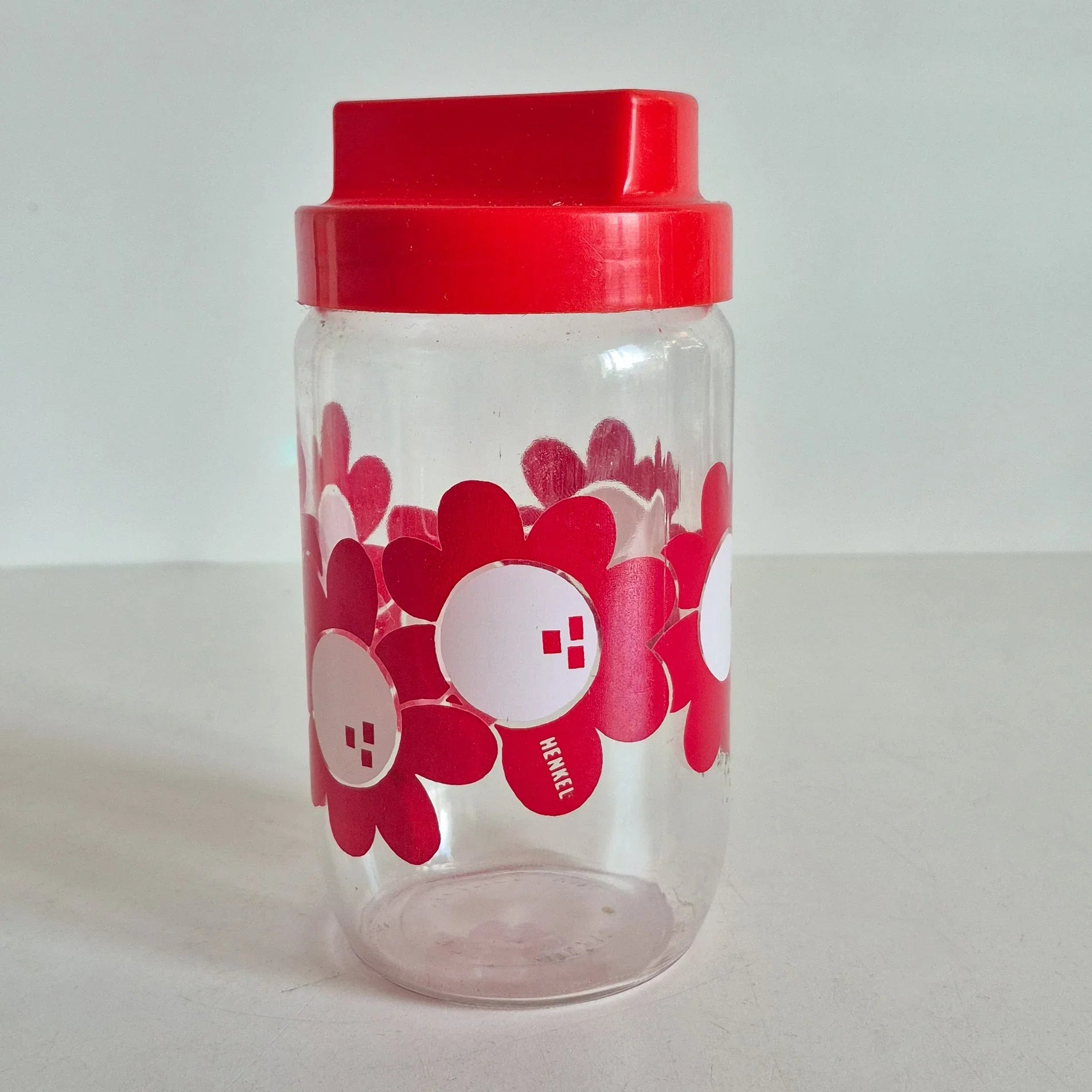 Bocal Henkel fleur rouge en verre vintage